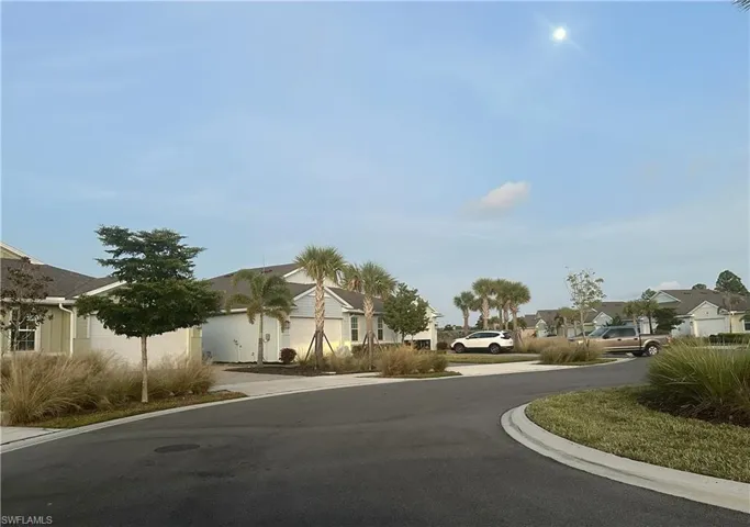 View of asphalt road featuring a residential view and curbs