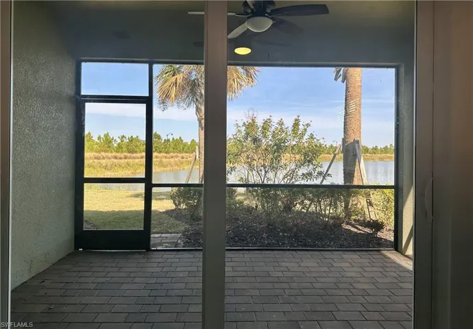 Unfurnished sunroom featuring ceiling fan and a water view