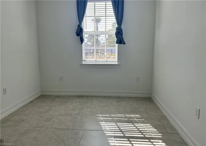 Unfurnished room featuring baseboards and light tile patterned floors