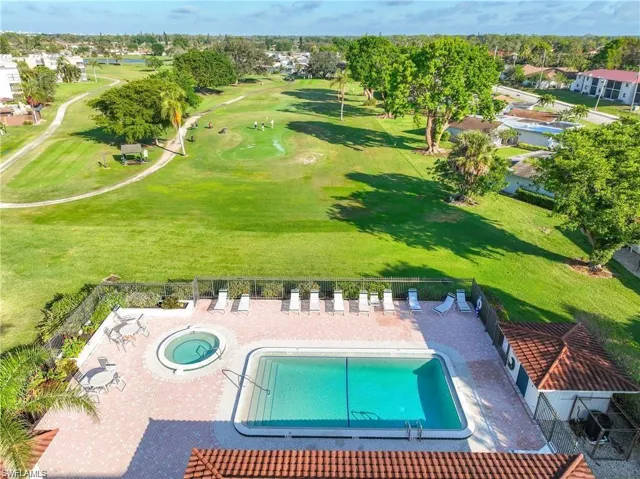 Drone / aerial view of a pool and a golf course