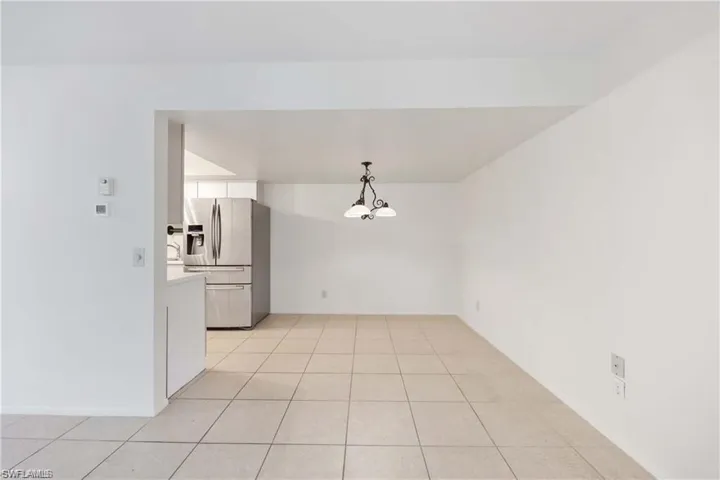 Unfurnished dining area with a chandelier and light tile patterned floors