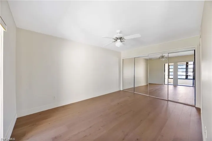 Unfurnished bedroom featuring wood finished floors, a closet, and ceiling fan