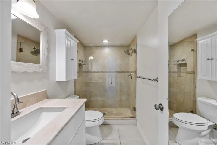 Bathroom with vanity, a stall shower, and light tile patterned floors