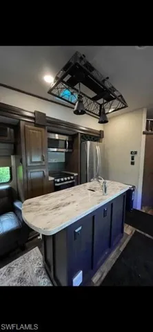Kitchen featuring appliances with stainless steel finishes, a kitchen island, and a sink