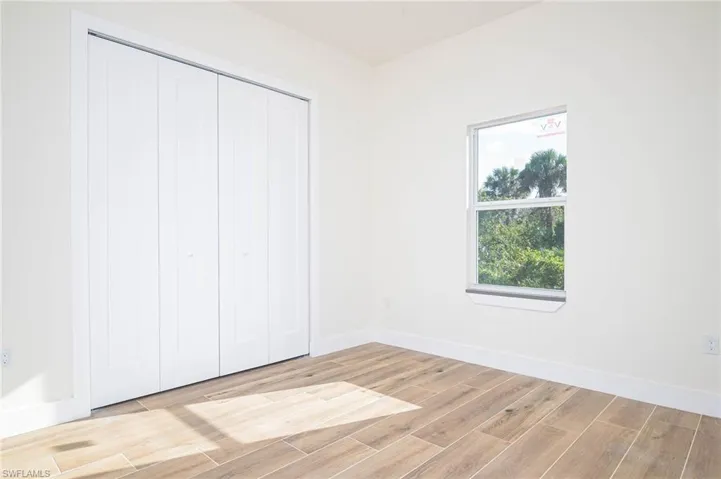Unfurnished bedroom with light hardwood / wood-style flooring and a closet