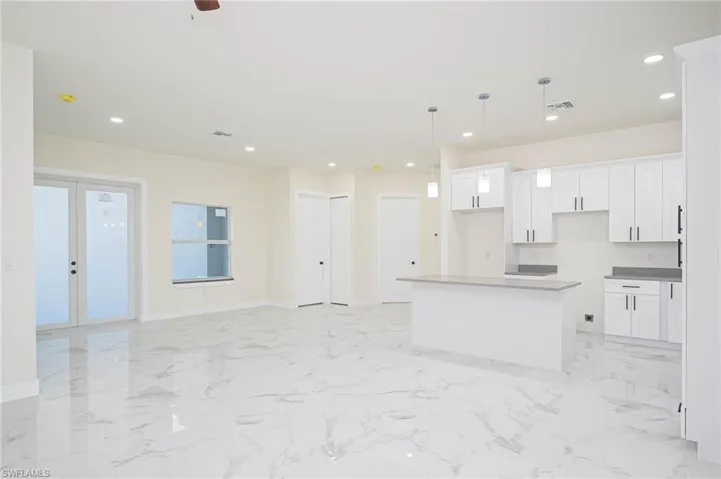 Kitchen featuring white cabinetry, pendant lighting, ceiling fan, and a center island