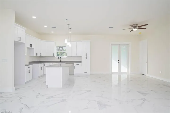 Kitchen featuring white cabinetry, pendant lighting, and a kitchen island