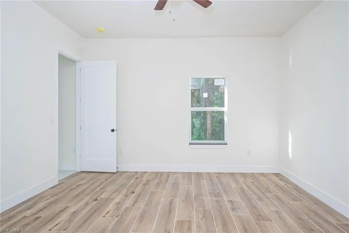 Empty room with ceiling fan and light hardwood / wood-style floors