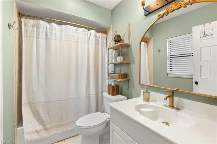 Bathroom featuring vanity, shower / tub combo