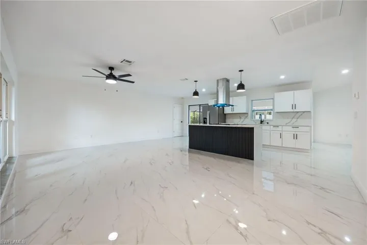 Unfurnished living room featuring light marble finish floors, recessed lighting, and ceiling fan