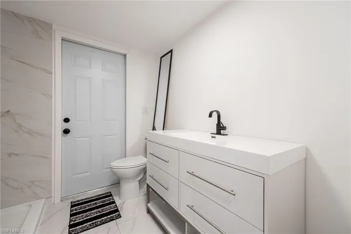 Full bathroom with vanity and light marble finish flooring