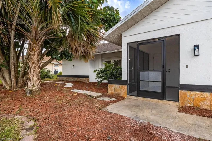 Doorway to property with stucco siding and a sunroom