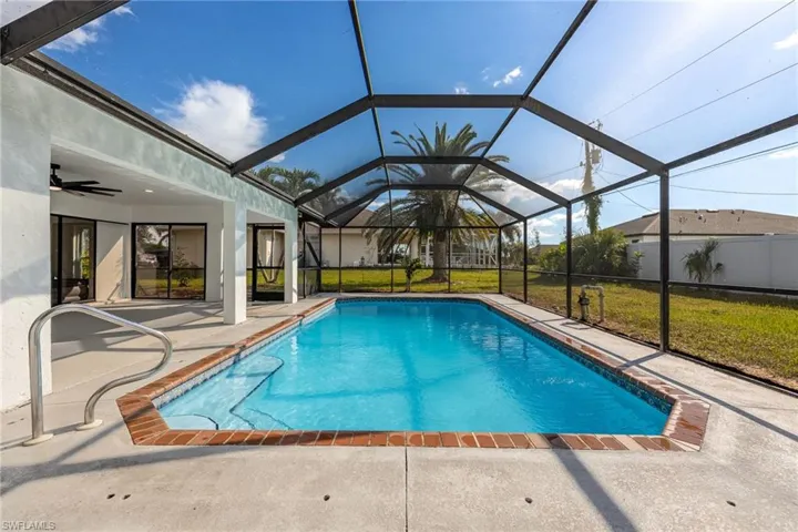 Swimming pool with a lawn, ceiling fan, a sunroom, and a patio