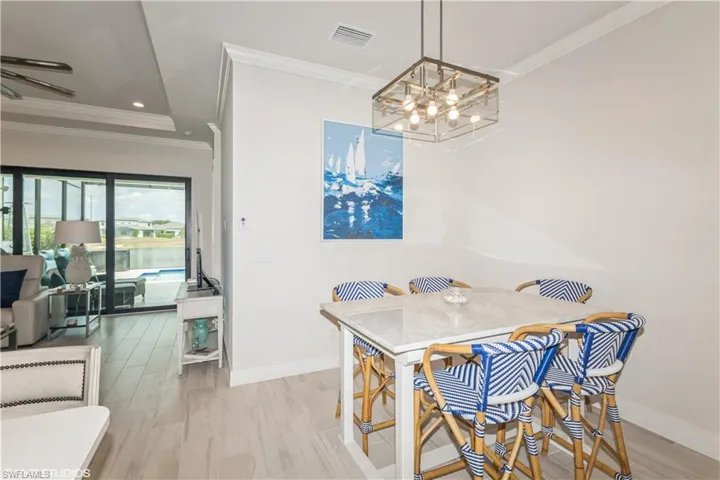 Dining area with a chandelier, crown molding, baseboards, and recessed lighting