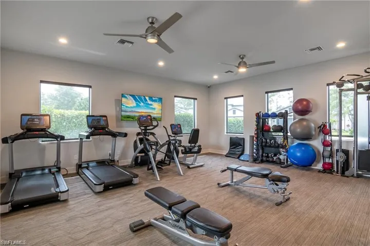 Gym with a ceiling fan, carpet flooring, and visible vents