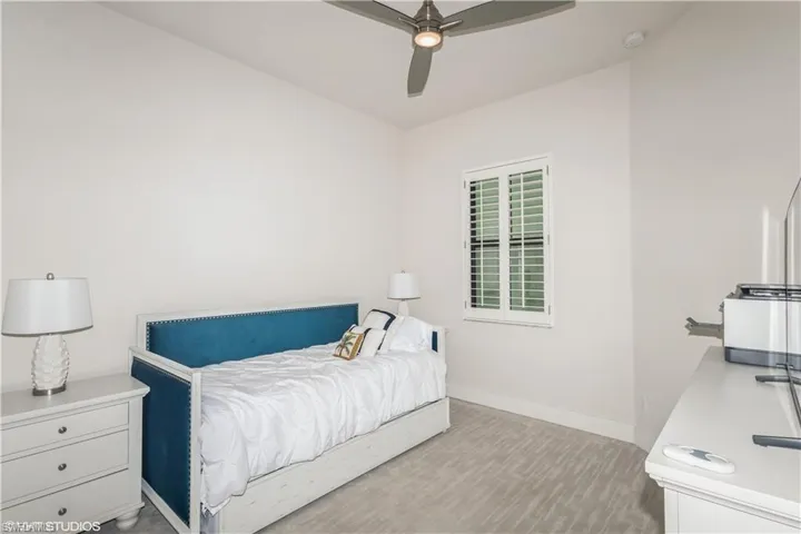 Bedroom featuring baseboards, a ceiling fan, and wood finished floors