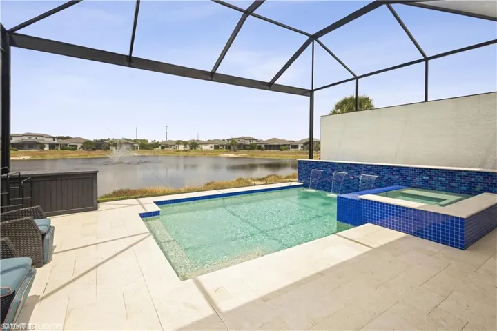 View of swimming pool featuring a water view, a patio area, and a lanai