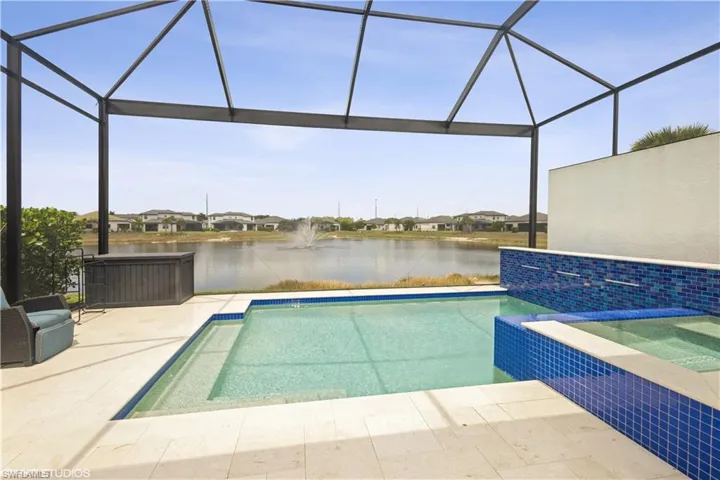 View of swimming pool with a water view, a pool with connected hot tub, a patio, and a lanai