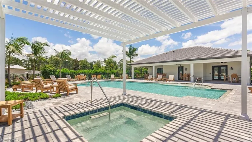 Pool featuring french doors, a patio area, fence, a community hot tub, and a pergola