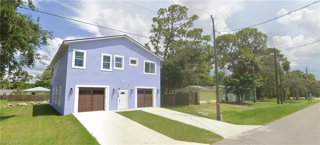 View of front of house with stucco siding and driveway