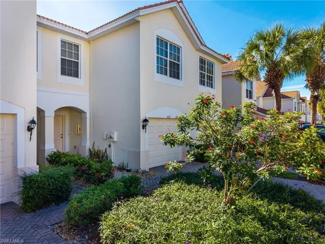 Tiled roof, stucco siding, and an attached garage