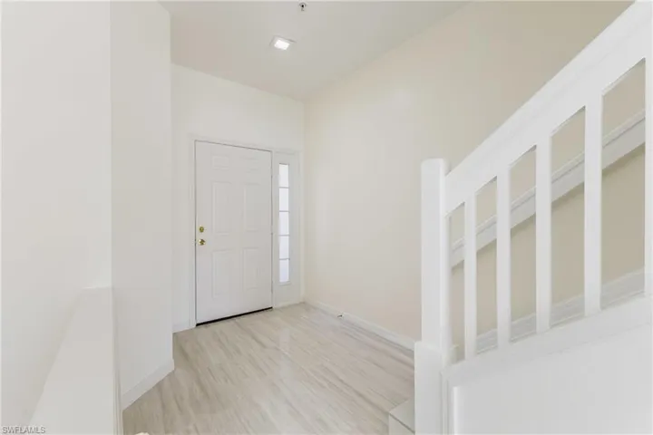 Foyer with light wood-style floors and baseboards
