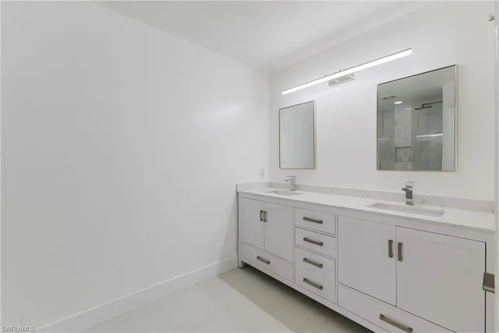 Bathroom with double vanity and a shower with shower door