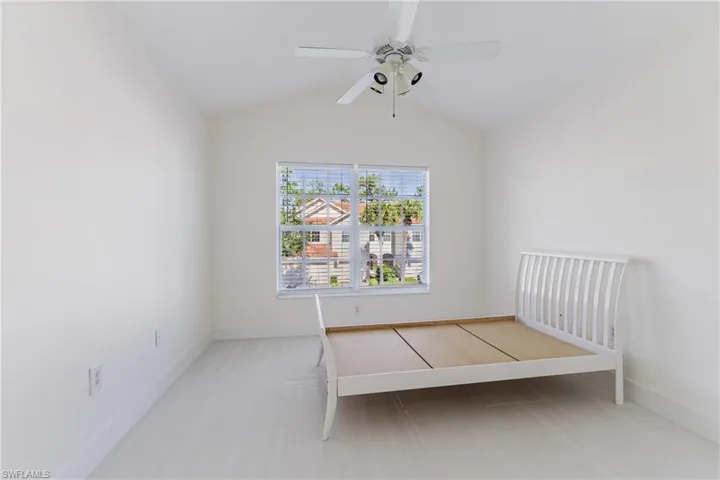 Unfurnished bedroom with lofted ceiling and ceiling fan