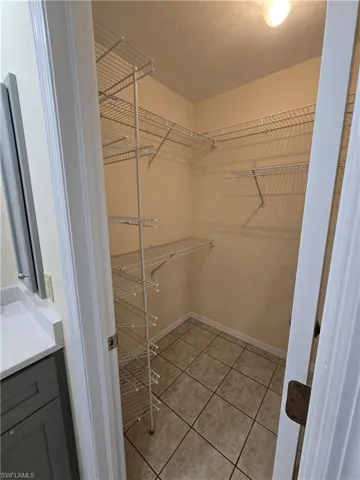 Walk in closet with light tile patterned floors