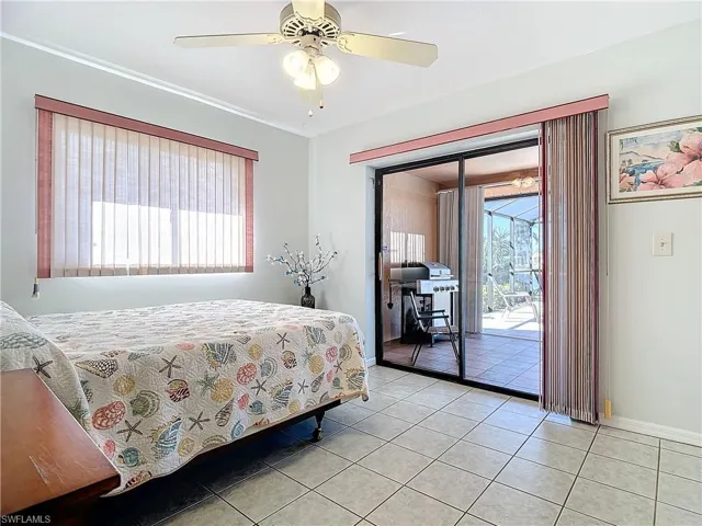 Tiled bedroom with access to exterior and ceiling fan