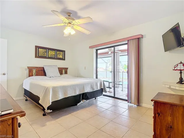 Tiled bedroom with ceiling fan and access to exterior