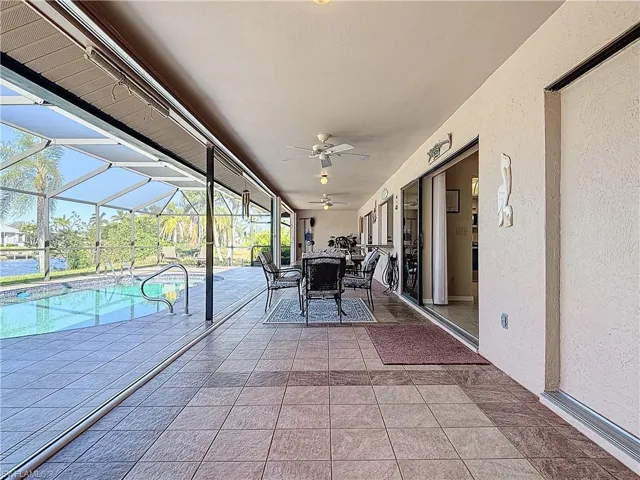 View of patio featuring glass enclosure and ceiling fan