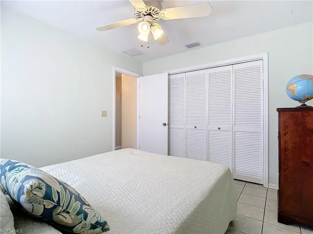 Bedroom featuring a closet, ceiling fan, and light tile patterned flooring