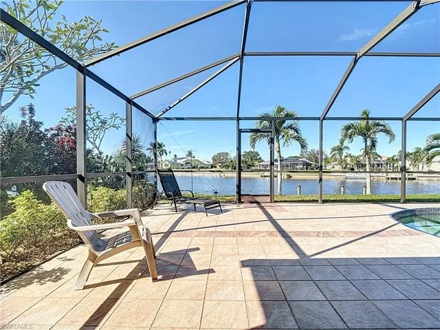 View of patio with glass enclosure and a water view