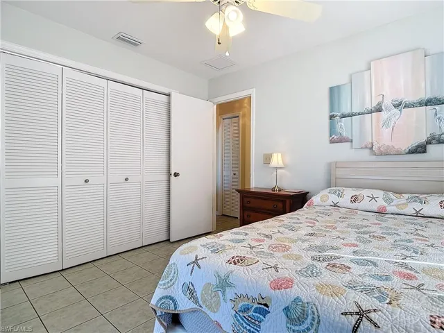 Tiled bedroom with a closet and ceiling fan