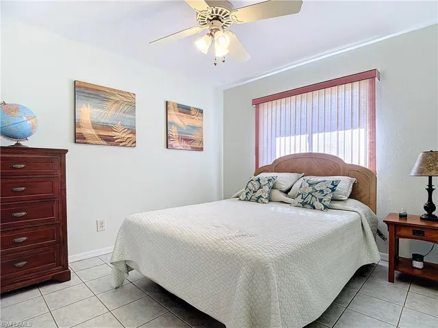 Bedroom with ceiling fan and light tile patterned flooring