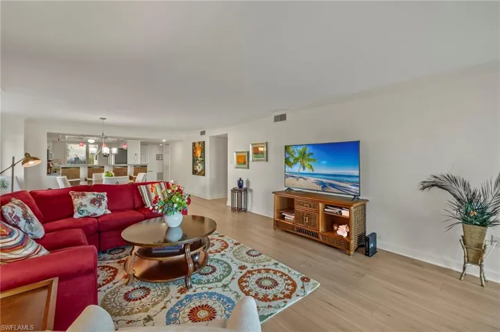Living room featuring light hardwood / wood-style floors, ornamental molding, and an inviting chandelier