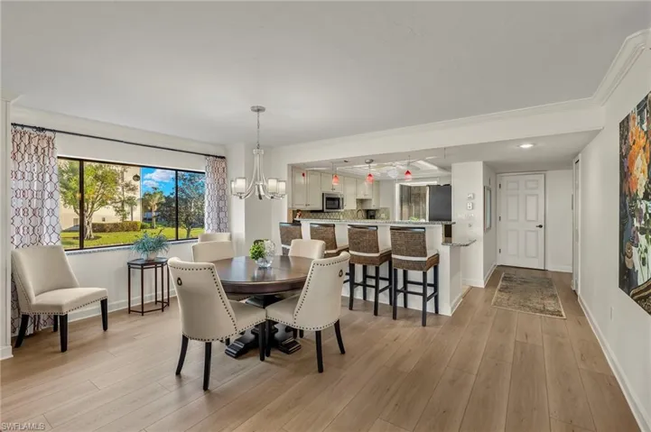 Dining area with a chandelier, crown molding, and light hardwood / wood-style floors