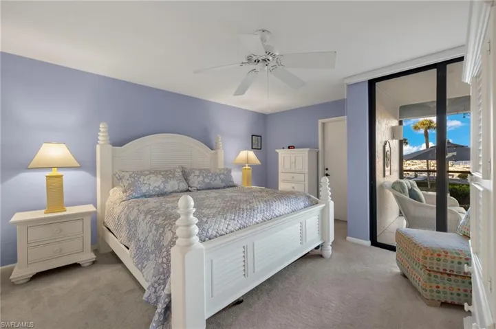 Carpeted bedroom featuring access to outside and ceiling fan