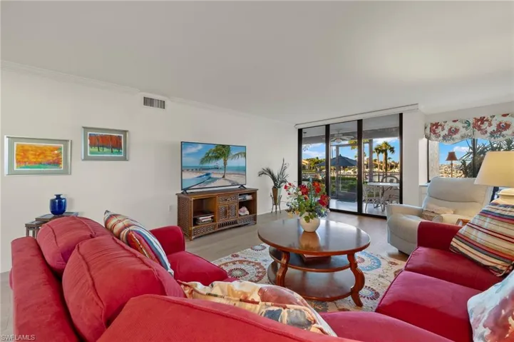 Living room featuring expansive windows, light wood-type flooring, and crown molding
