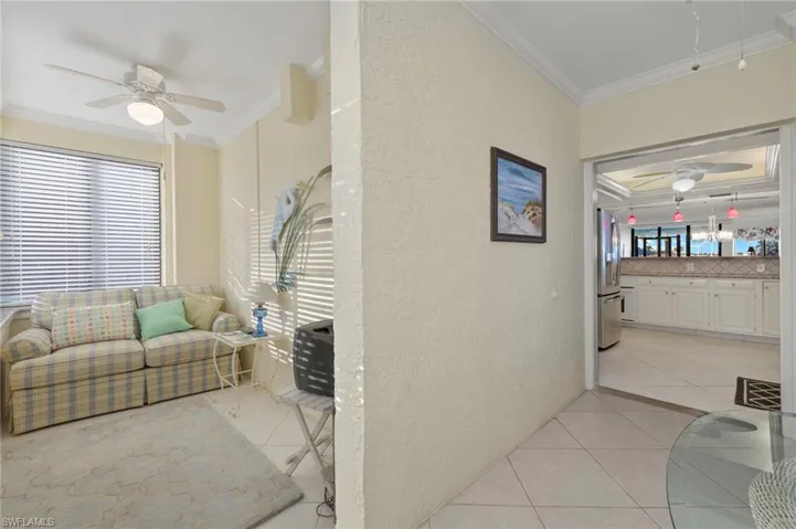 Living room with light tile patterned flooring and crown molding