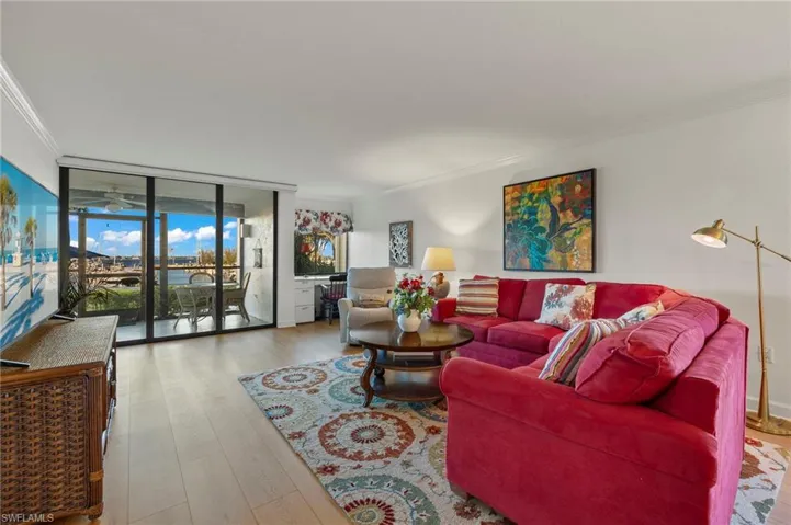 Living room with crown molding, expansive windows, and hardwood / wood-style flooring