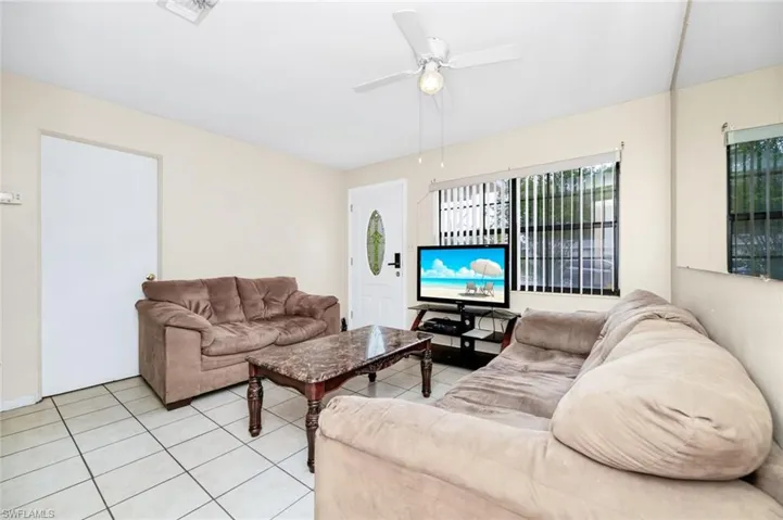 Living area with visible vents, a ceiling fan, and light tile patterned floors