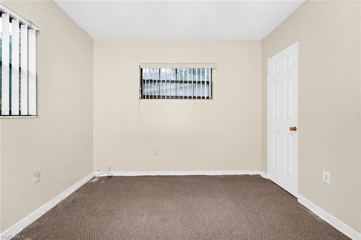 Empty room with carpet floors and baseboards