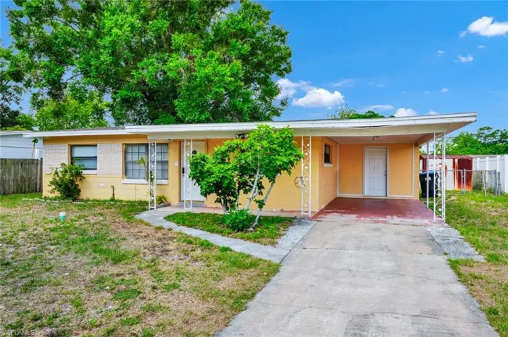 Single story home with fence, driveway, and an attached carport