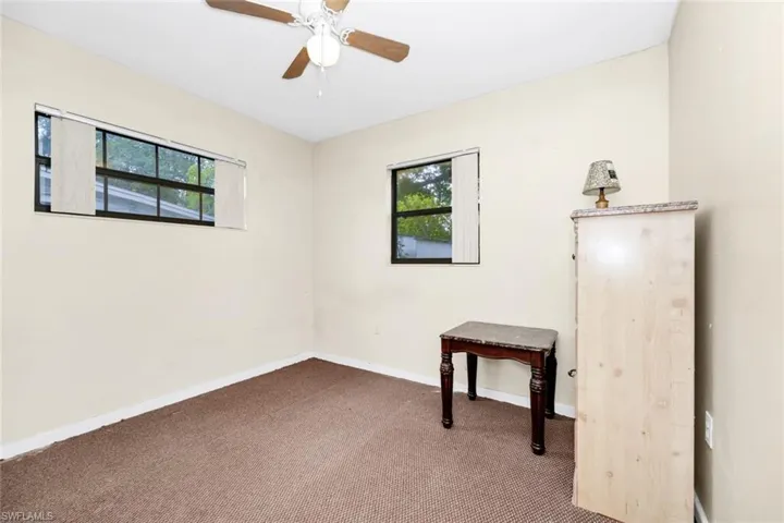 Carpeted empty room featuring baseboards and a ceiling fan