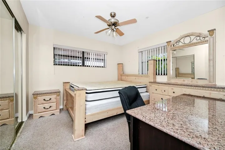 Bedroom featuring light colored carpet, a ceiling fan, and a closet