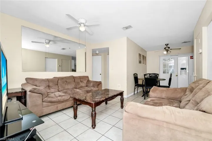 Living area featuring ceiling fan, visible vents, and light tile patterned floors