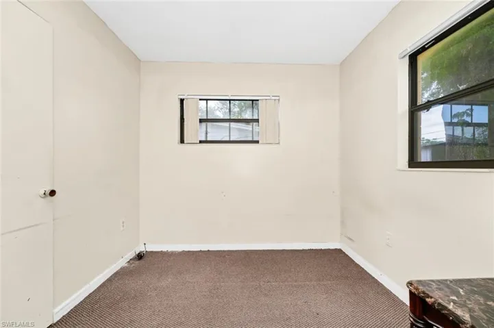 Empty room with carpet floors and baseboards