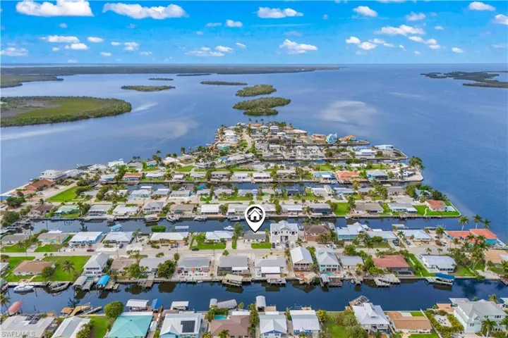Overhead perspective showing the property in context with the water, canals, and neighboring homes.